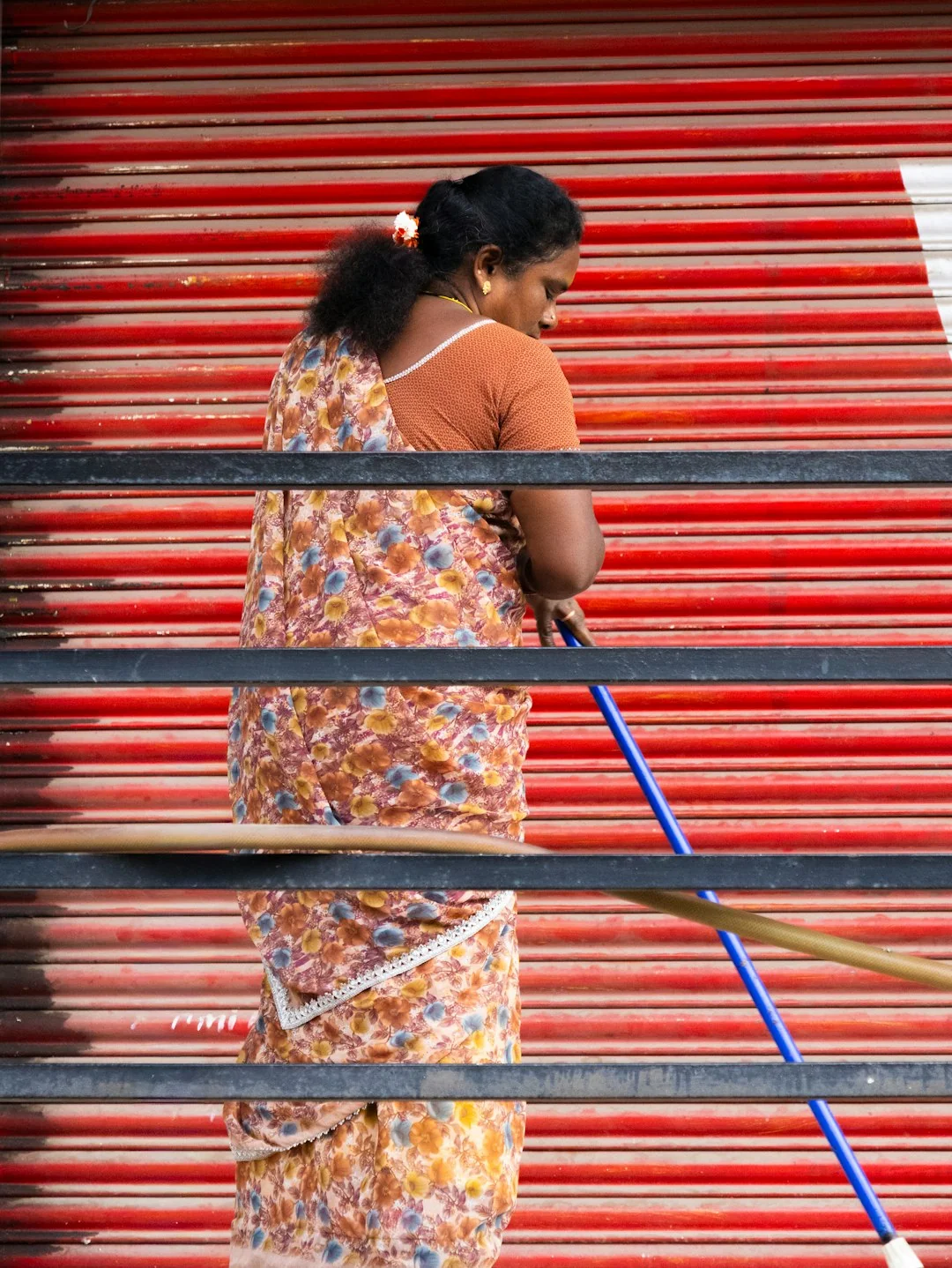A worker cleaning skyscraper windows with a harness in an urban setting.